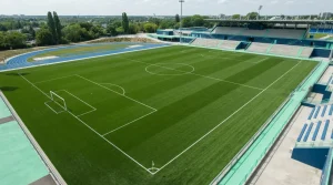 Grüne Rasenfläche eines Fußballfelds mit weißen Seiten- und Mittellinien
